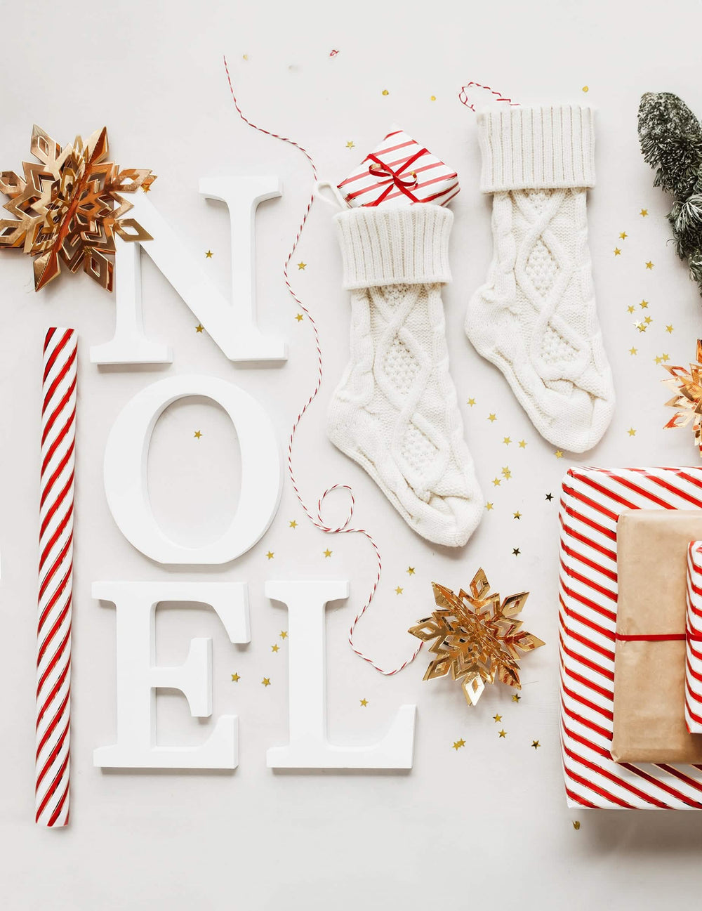 Encenação com letras NOEL e suspensões em cartão com flocos de neve dourados