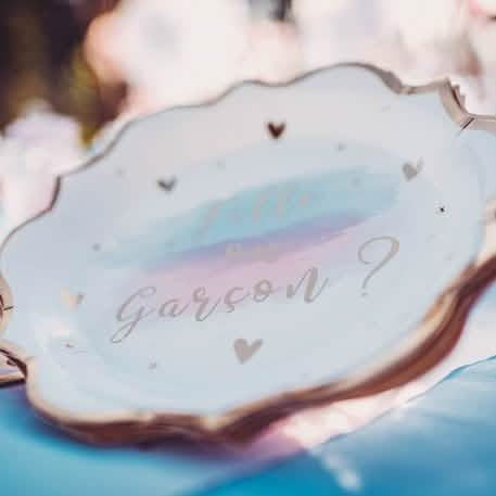 Primeiro plano da inscrição dos pratos de cartão menina ou menino para baby shower