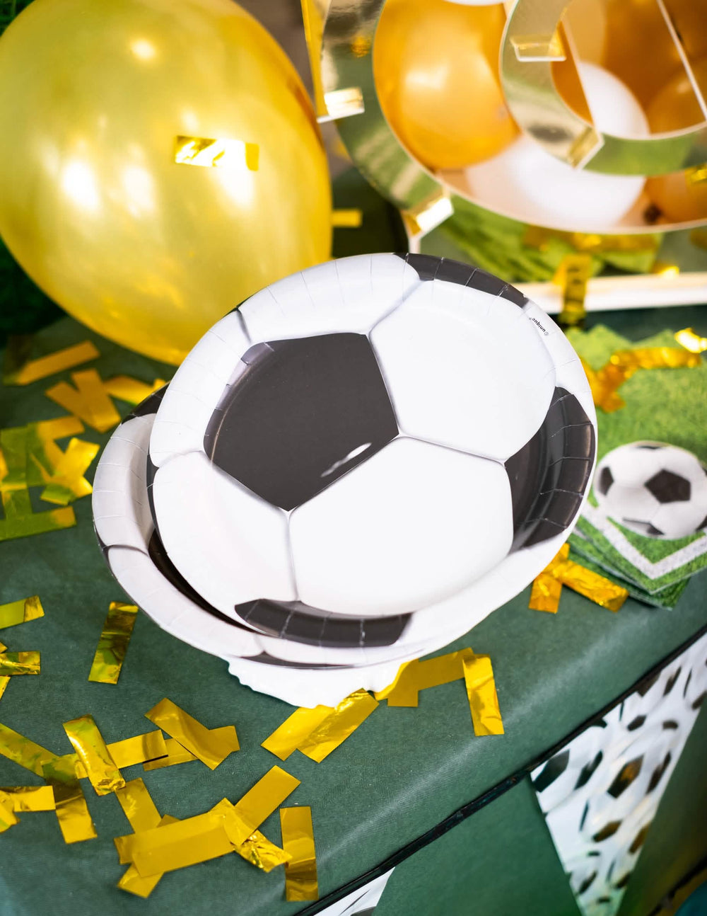 Montagem numa mesa de festa de pratos de cartão de futebol