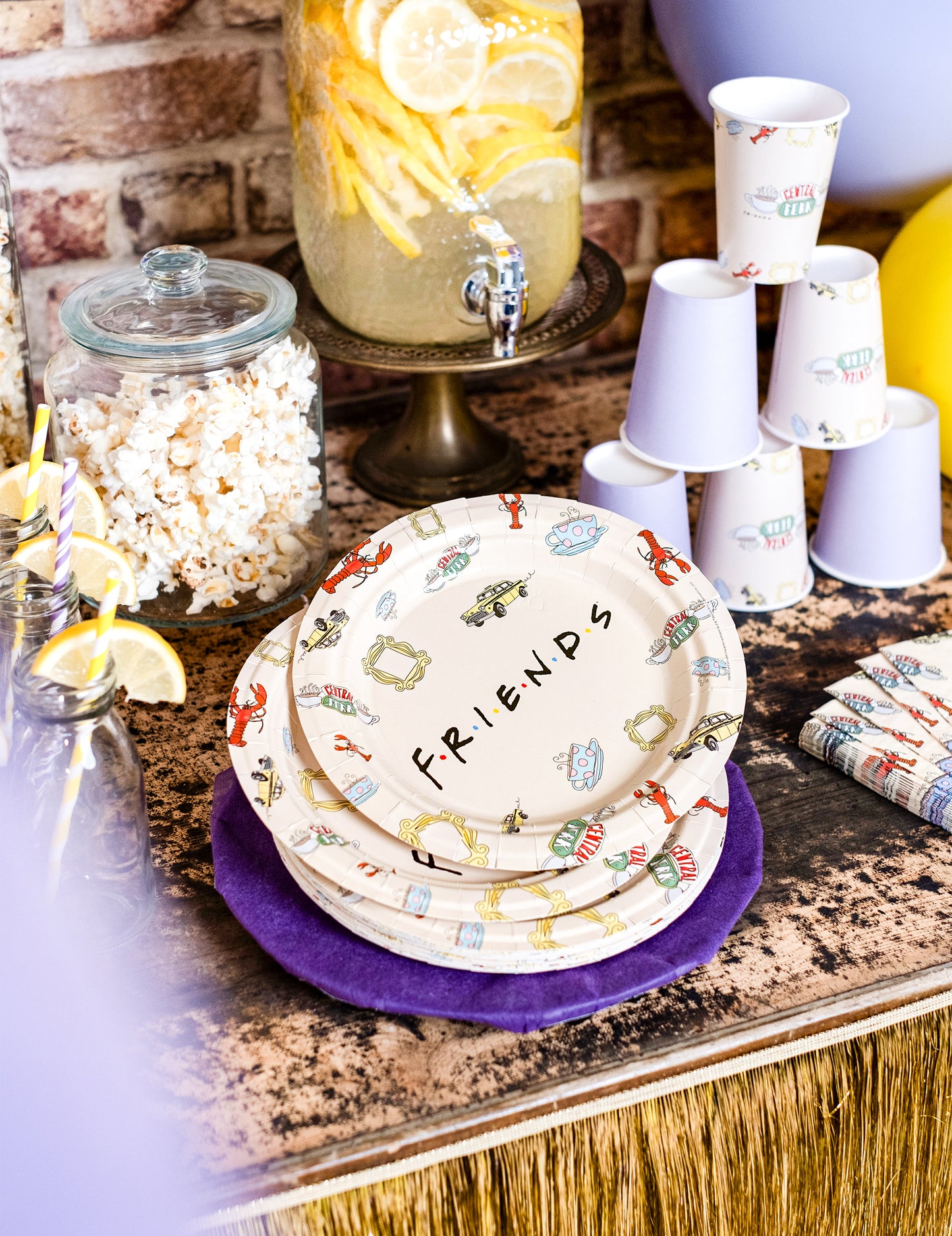Mise en situation des assiettes en carton Friends sur une table de fête