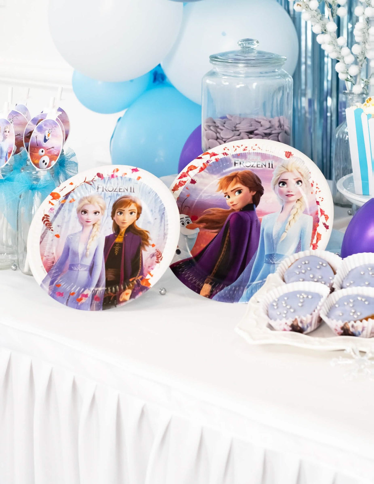 Colocação numa mesa de festa de pratos de cartão Frozen 2