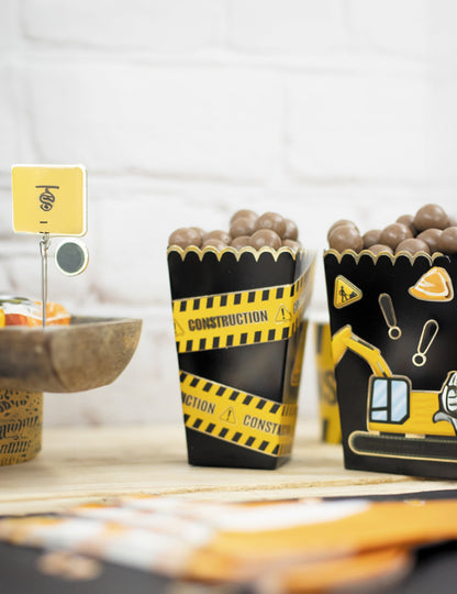 Zoom sur le contenu des boîtes à pop-corn festonnées pour fête noires et or