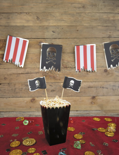 Mise en situation sur le thème pirate des boîtes à pop-corn festonnées pour fête noires et or