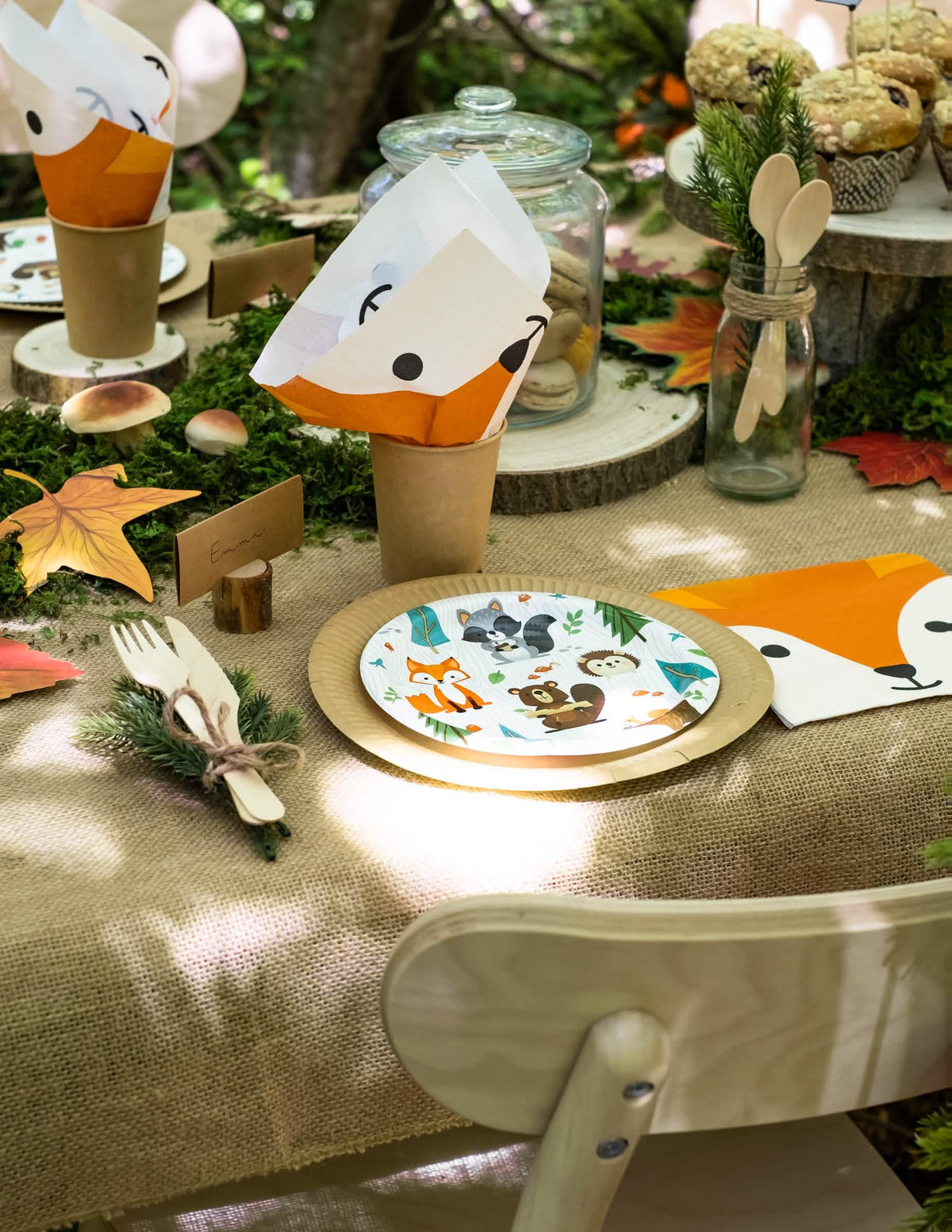 Encenação de mesa de aniversário com pratos pequenos de cartão de animal da floresta