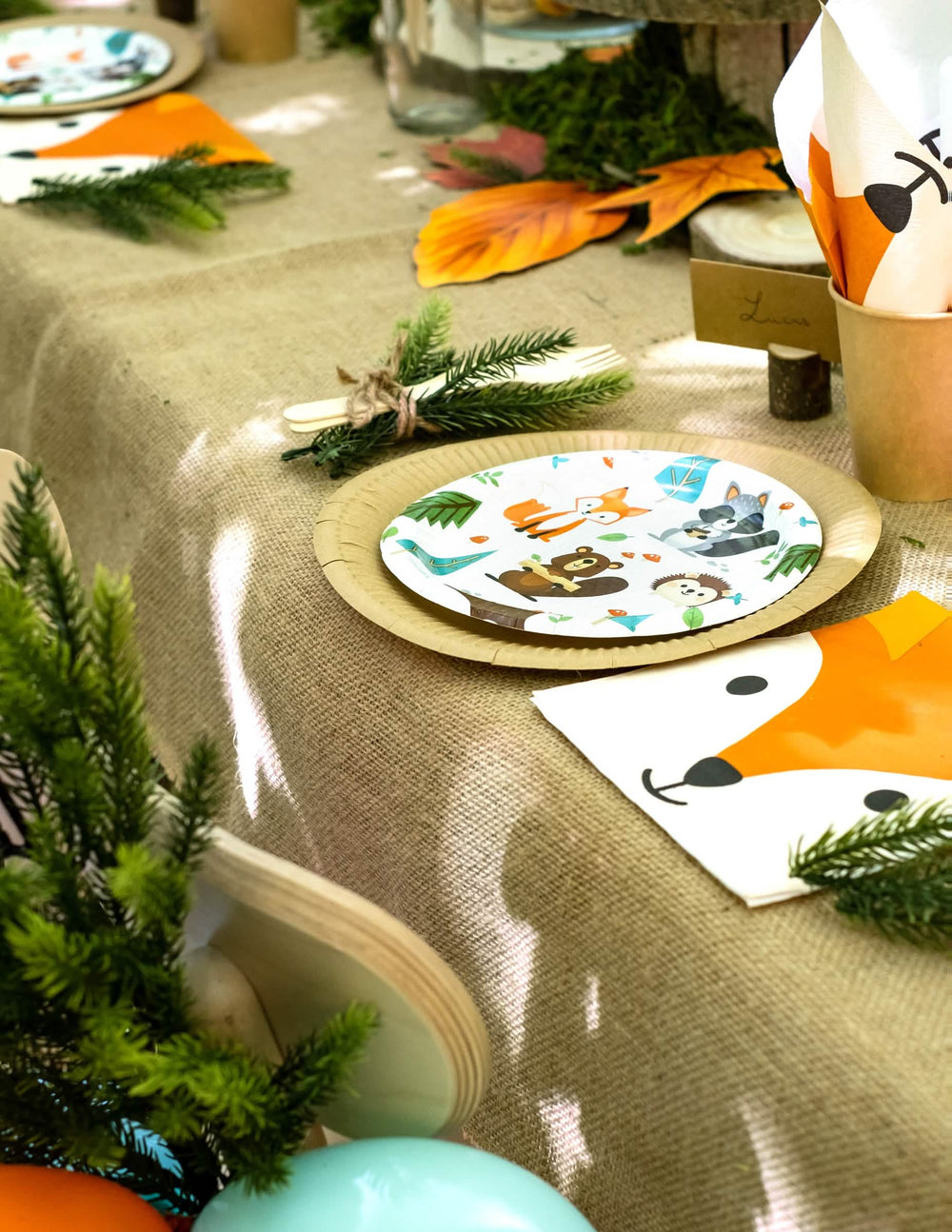 Grande plano sobre a mise en place da mesa dos pequenos pratos de cartão animal da floresta