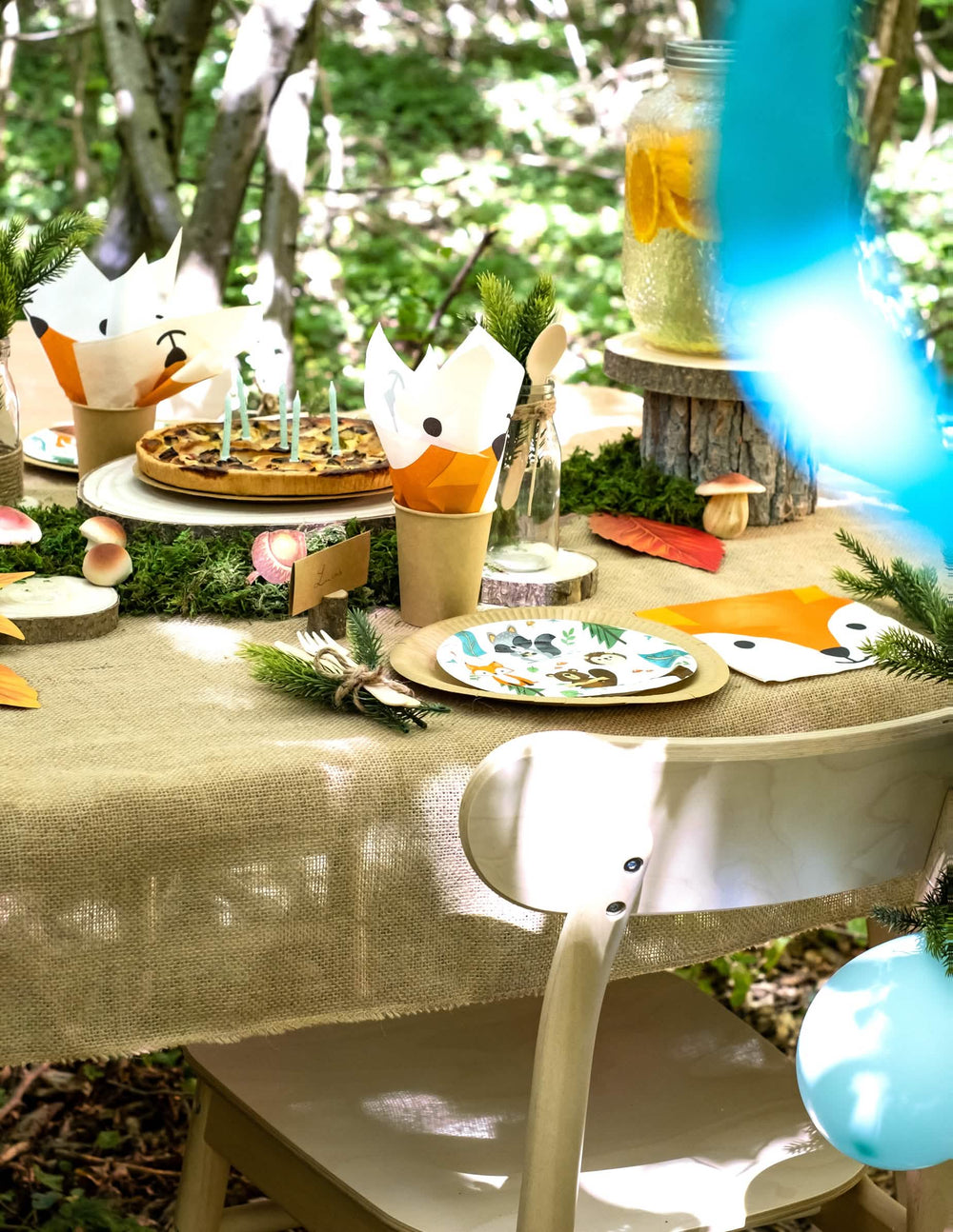 Vista geral da mesa de festa dos pratos de cartão animal da floresta para aniversário