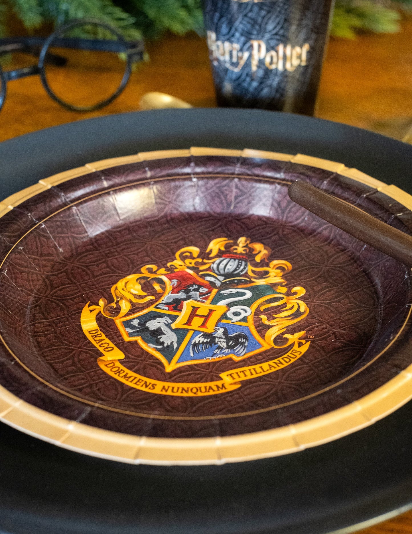Gros plan sur le blason Poudlard de l'assiette en carton Harry Potter
