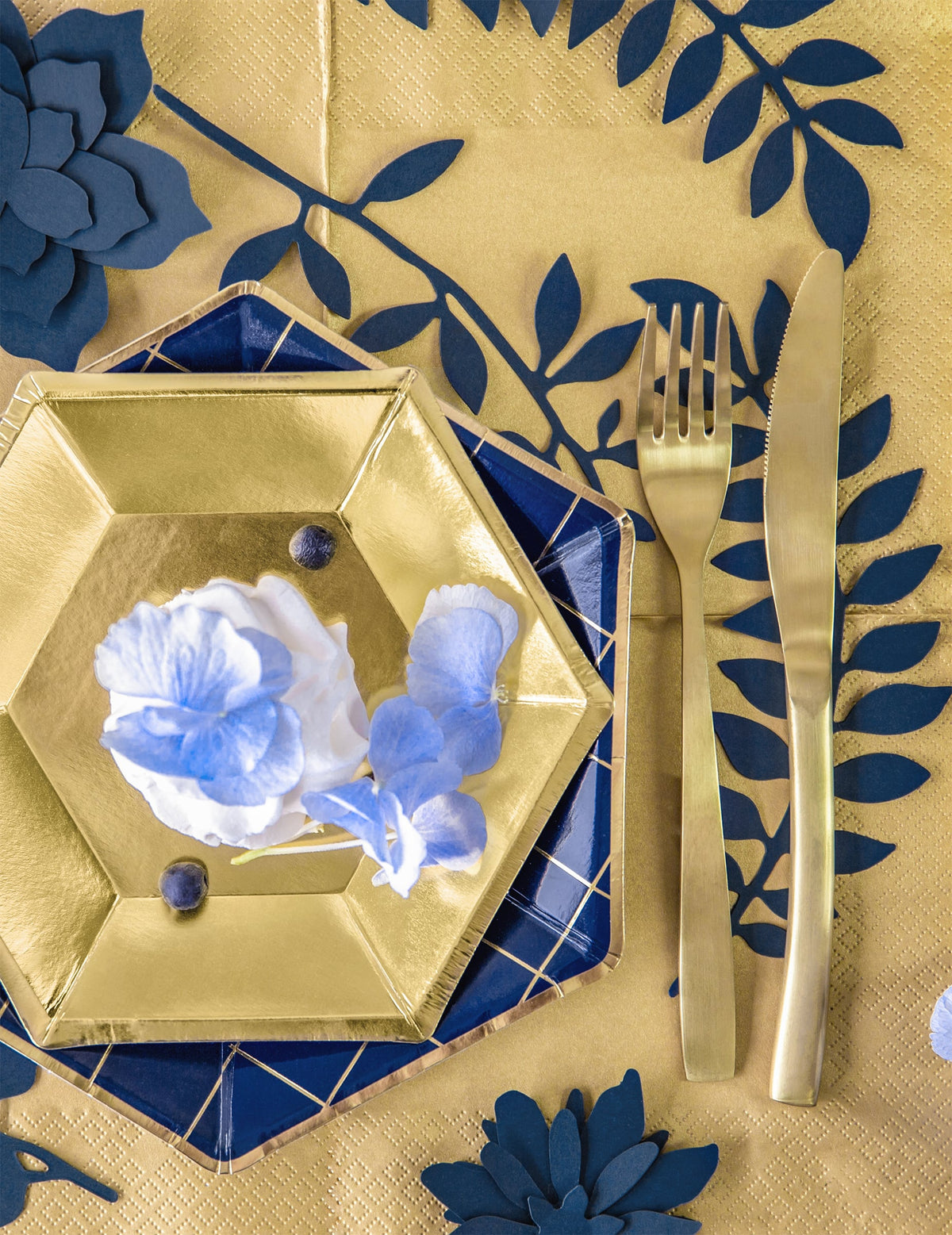 Vue de dessus d'un dressage de table avec les décorations de table feuilles pour fête bleu marine en papier