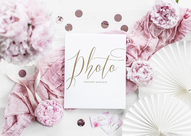 Mise en scène avec décor floral de l'album photo mariage blanc et doré