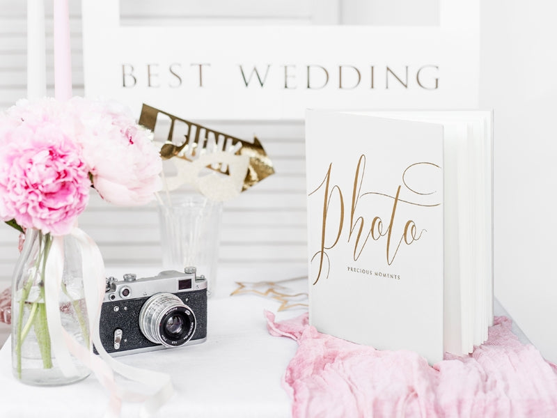 Mise en scène avec accessoires et appareil photo de l'album photo mariage blanc et doré