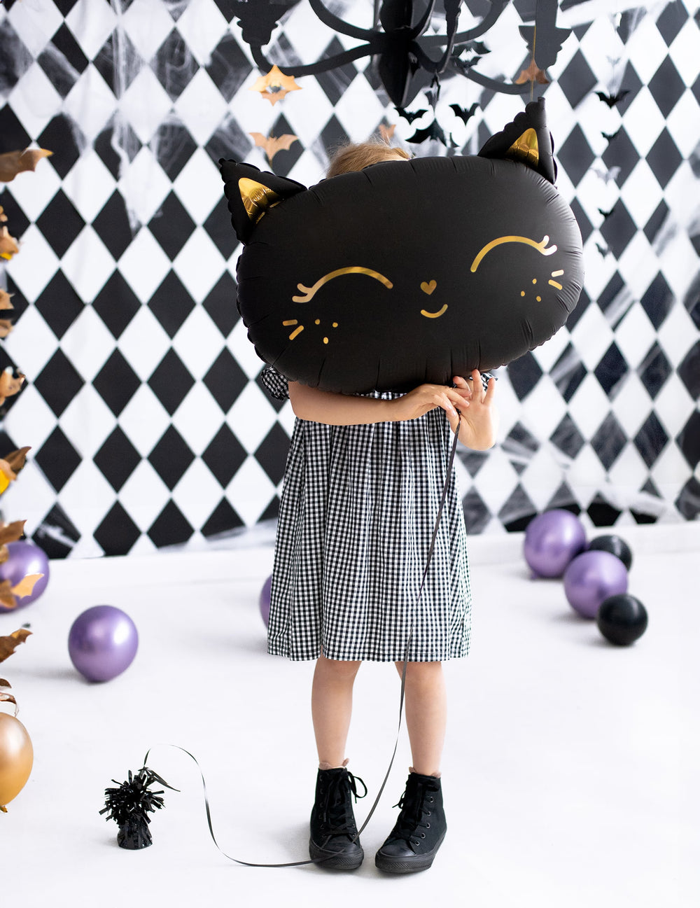 Enfant tenant devant son visage le ballon aluminium chat pour Halloween