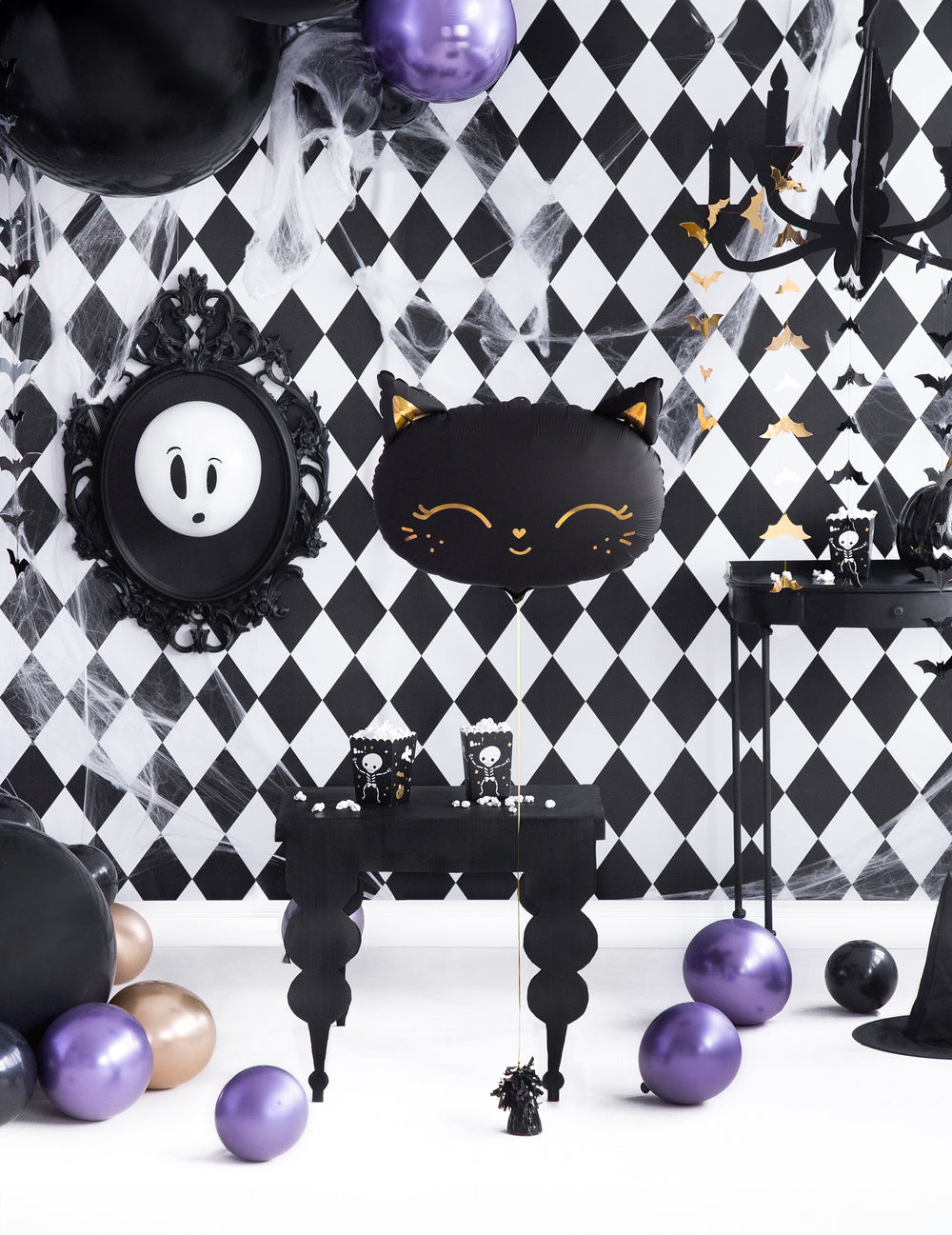 Mise en scène dans un décor noir et blanc du ballon aluminium chat pour Halloween