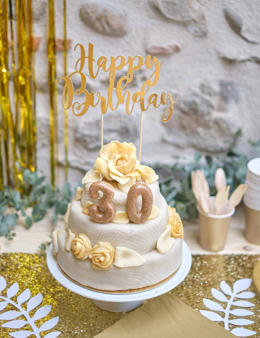 Ambiente de festa à volta do bolo da vela com o número 3 para aniversário dourado com brilhantes