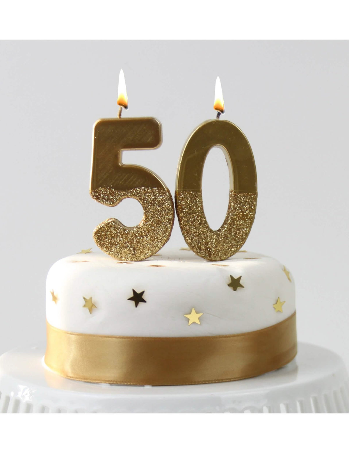 Topo de bolo de vela sobre espeto em forma de número dourado com brilho glitterizado