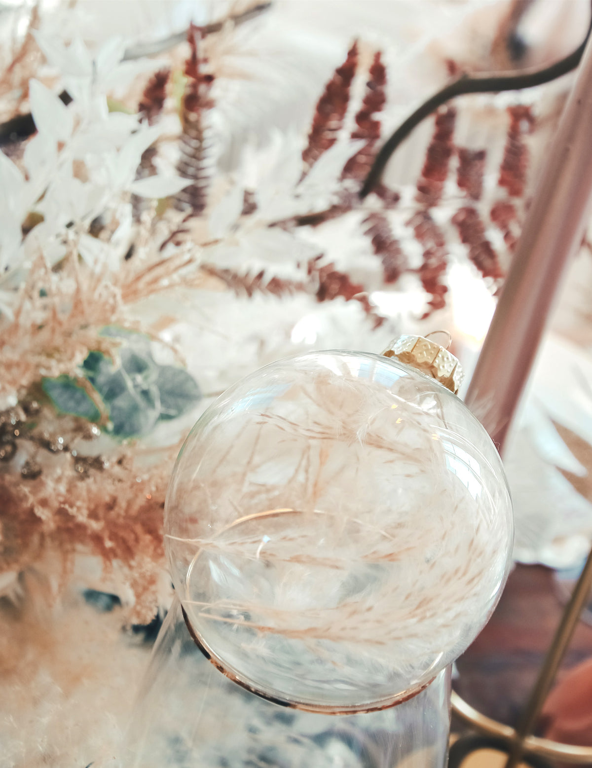 Détail des plumes à l'intérieur de la boule de noël personnalisable pour décoration transparente à suspendre