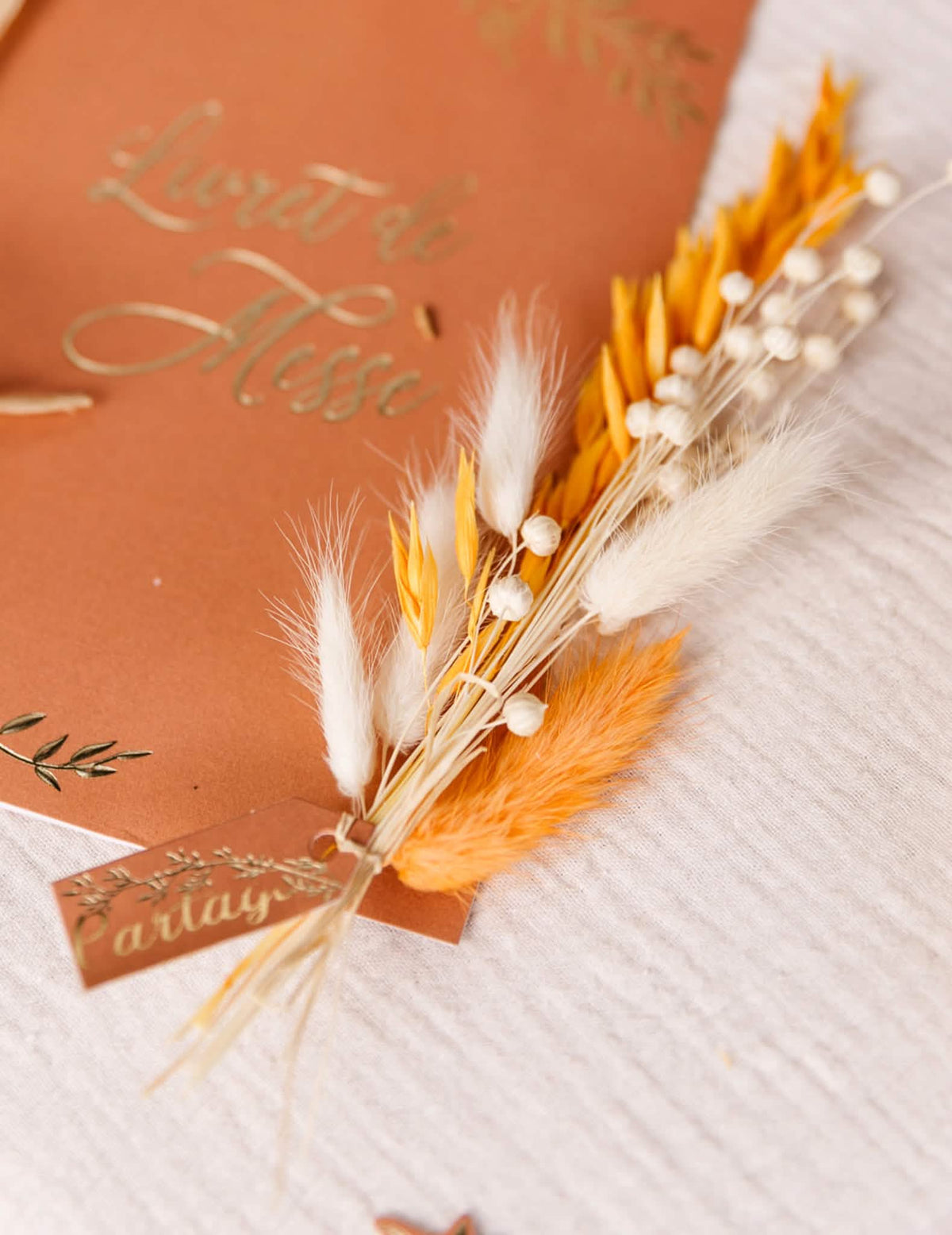 Detalhe da utilização num folheto de missa do bouquet boémio de linho seco