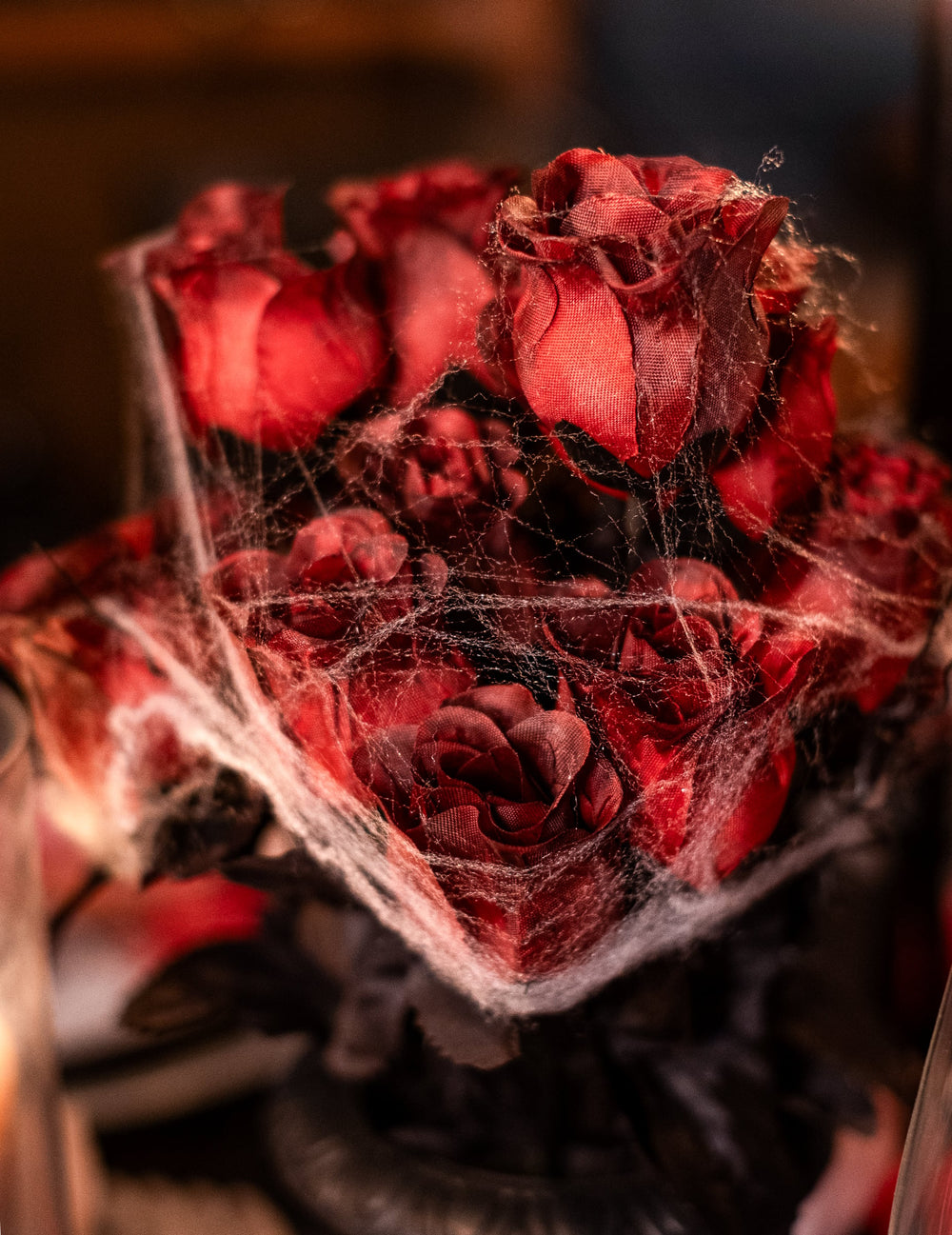 Gros plan sur la toile d'araignée du bouquet de roses rouges Halloween