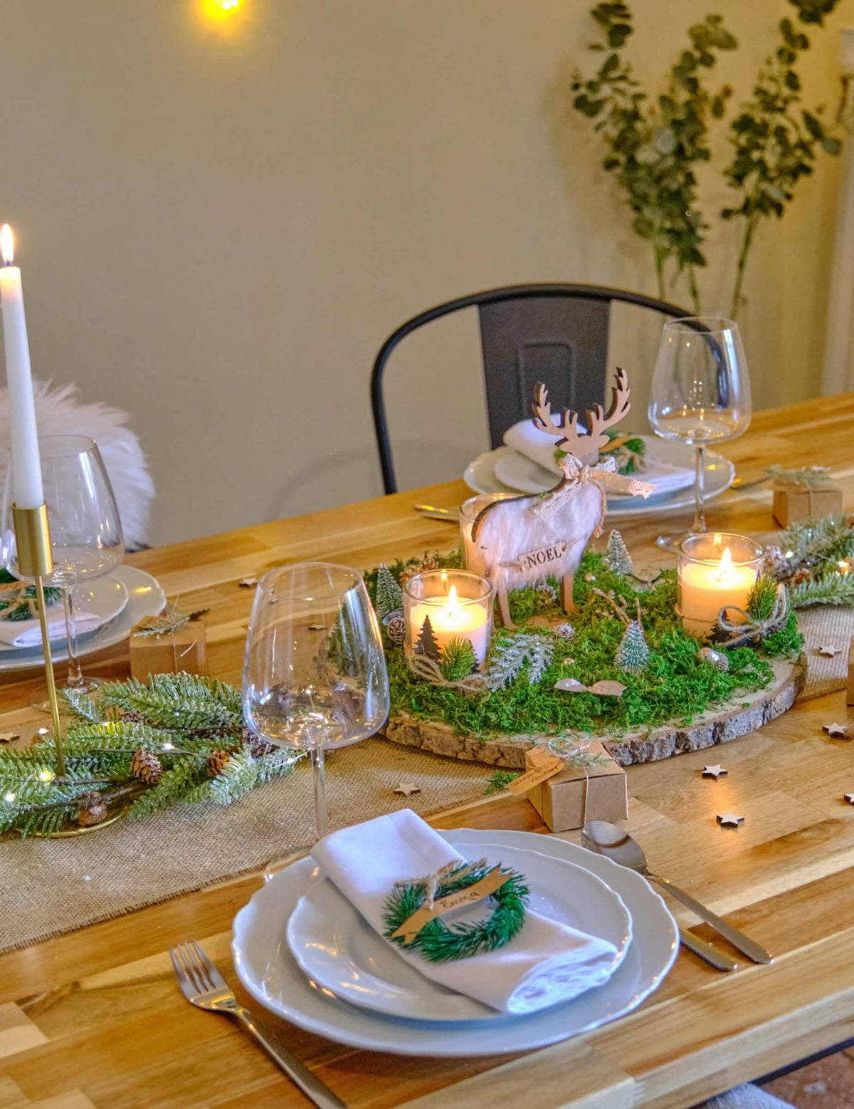 Decoração de mesa festiva com ramo de pinheiro coberto de neve e pinhas