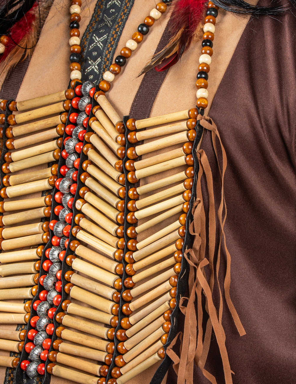Gros plan sur le plastron de perles et les franges du bustier indien pour adulte