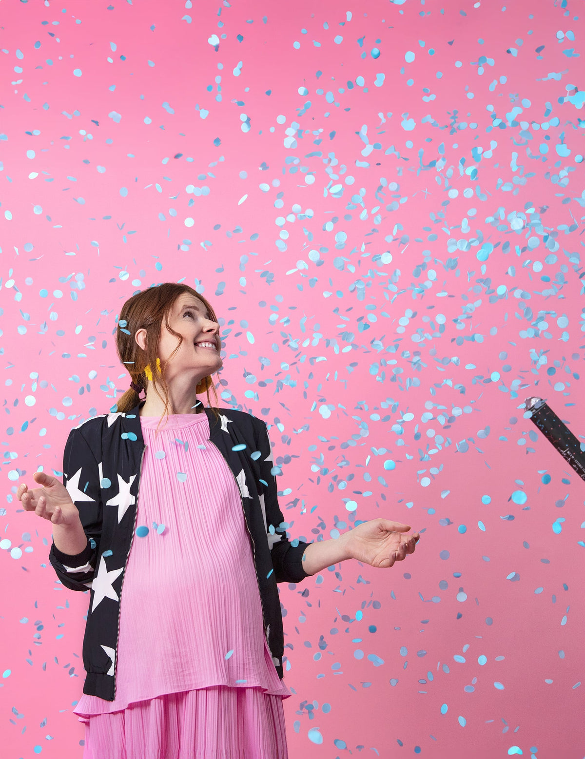 Pluie de confettis bleus sur une femme enceinte du canon à confettis boy pour baby shower