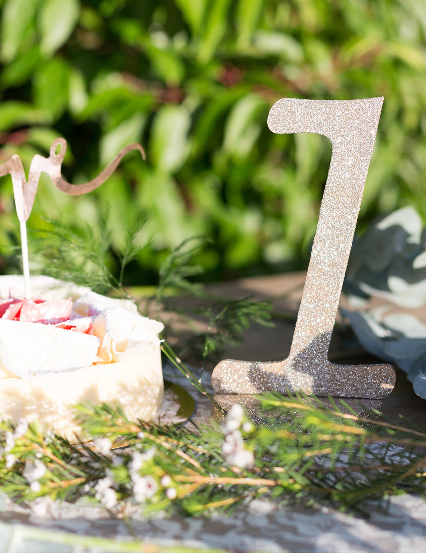 Gros plan du centre de table chiffre 1 pour anniversaire bois pailleté champagne