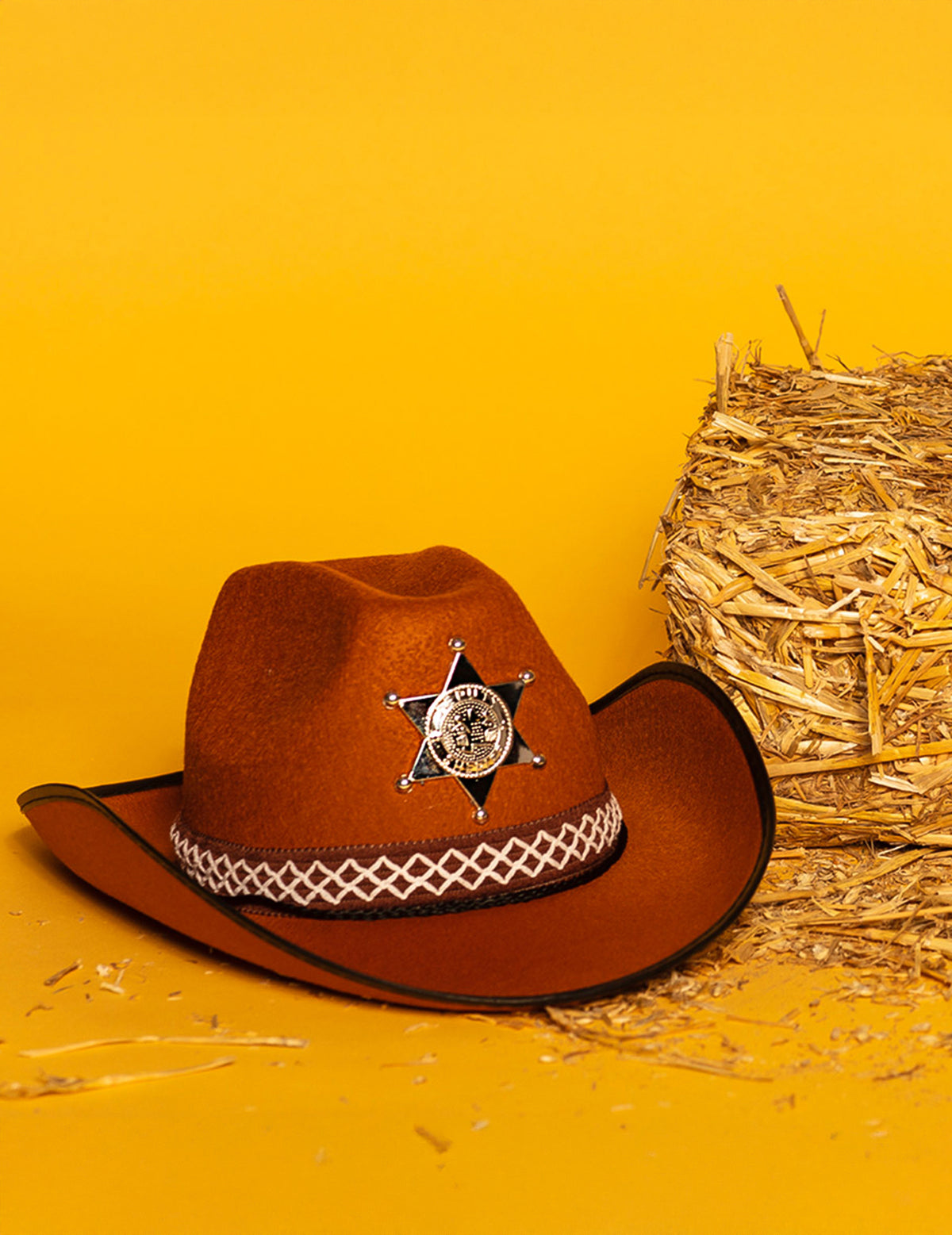 Mise en scène avec botte de paille du chapeau de sheriff pour enfant
