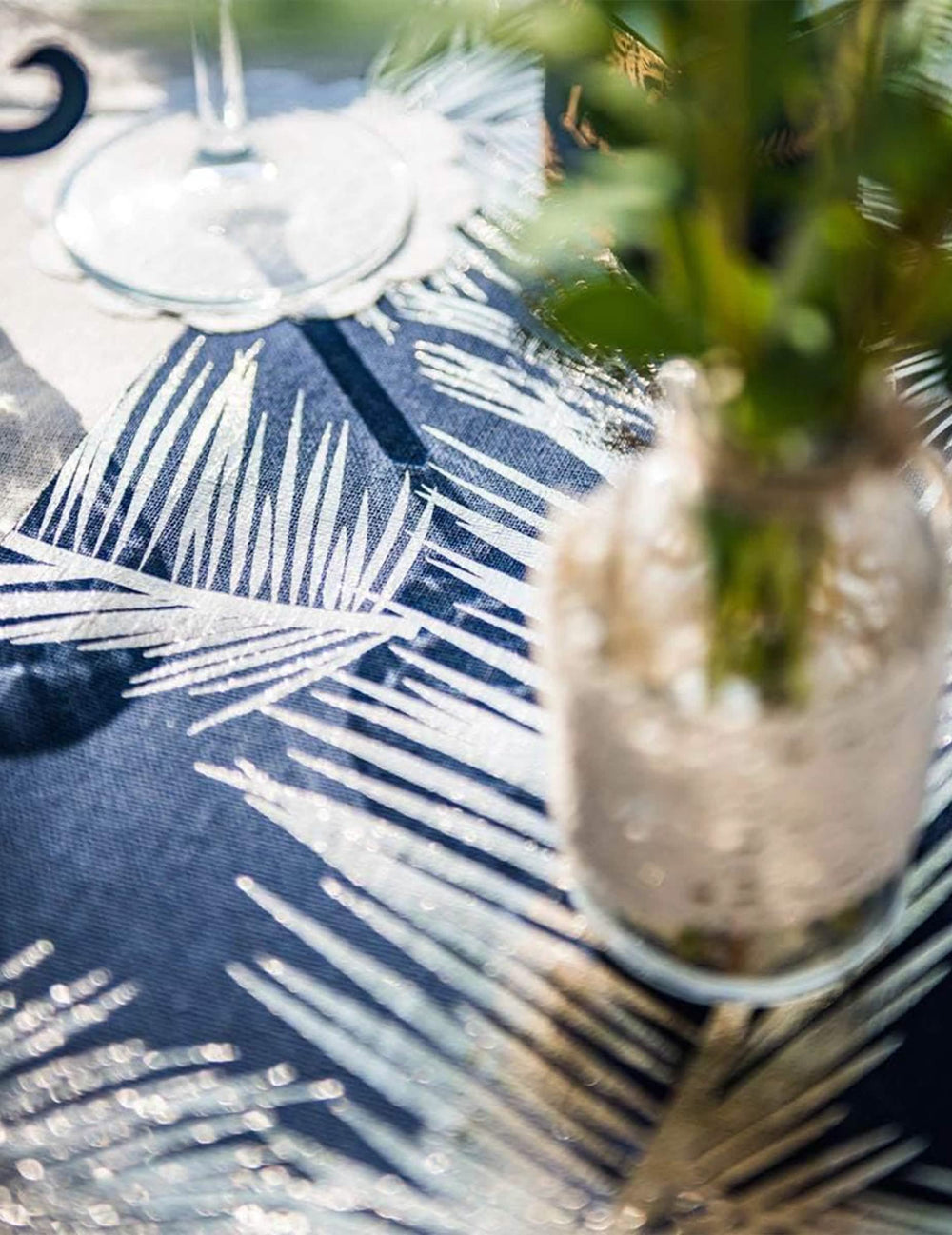 Grande plano dos motivos dourados do elegante caminho de mesa em linho com fetos