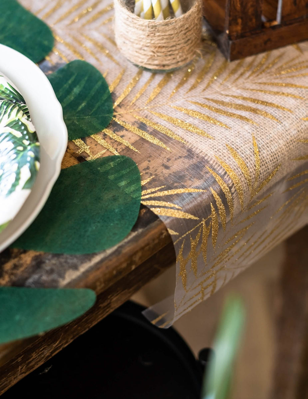 Detalhe dos motivos com lantejoulas do caminho de mesa em organza de palmeira para decoração tropical chique