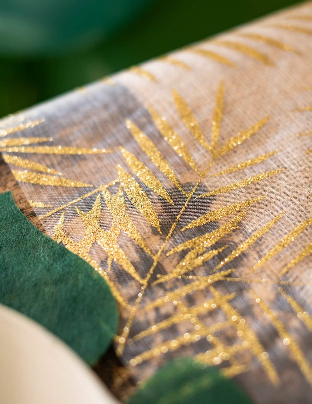 Grande plano sobre a textura da faixa de mesa em organza palmeira para decoração tropical chique com brilhantes dourados