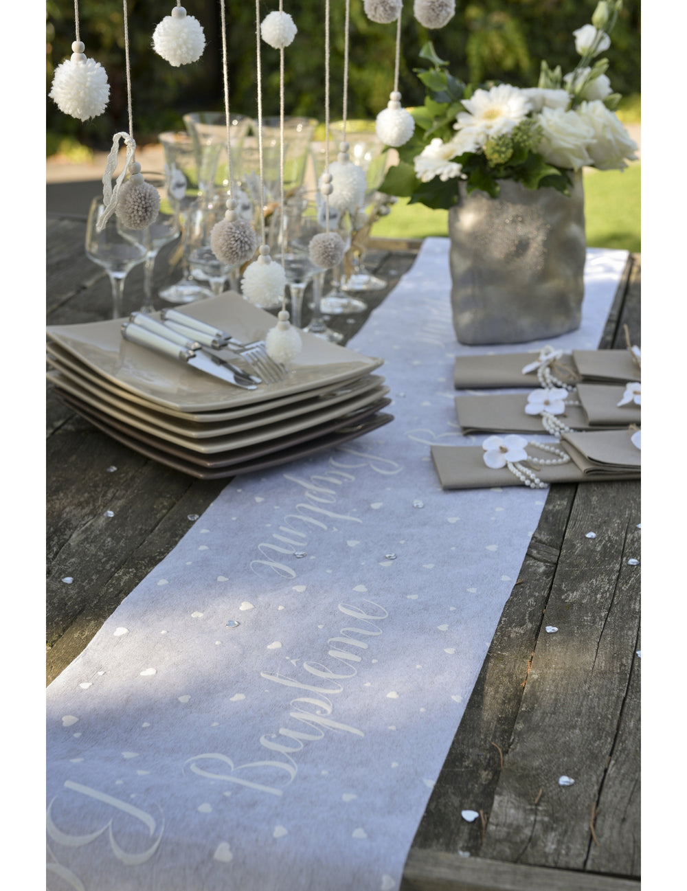 Mise en situation sur table du chemin de table intissé baptême blanc à cœurs gris