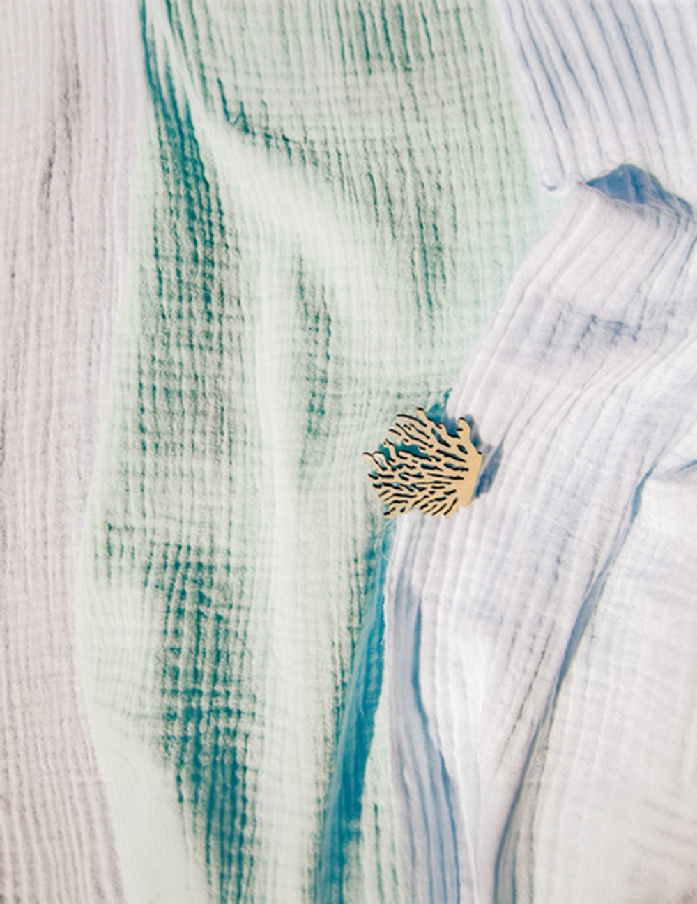 Détail de la texture du chemin de table en gaze de coton pour décoration de baptême bleu ciel