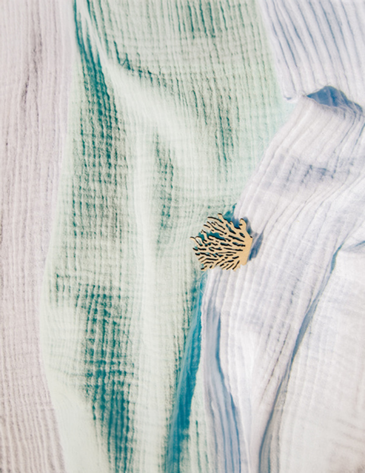 Détail de la texture du chemin de table en gaze de coton pour décoration de baptême bleu ciel