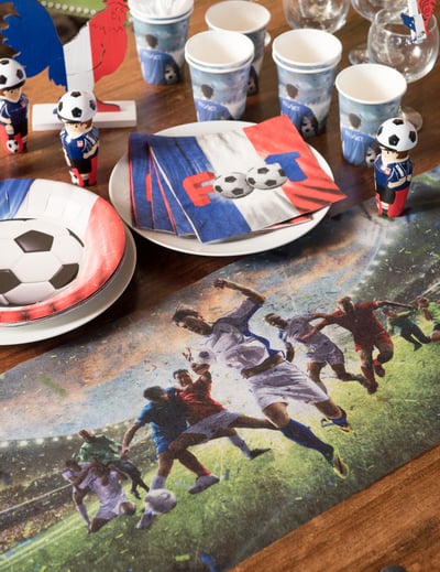 Mise en situation du chemin de table intissé champion de foot avec vaisselle assortie
