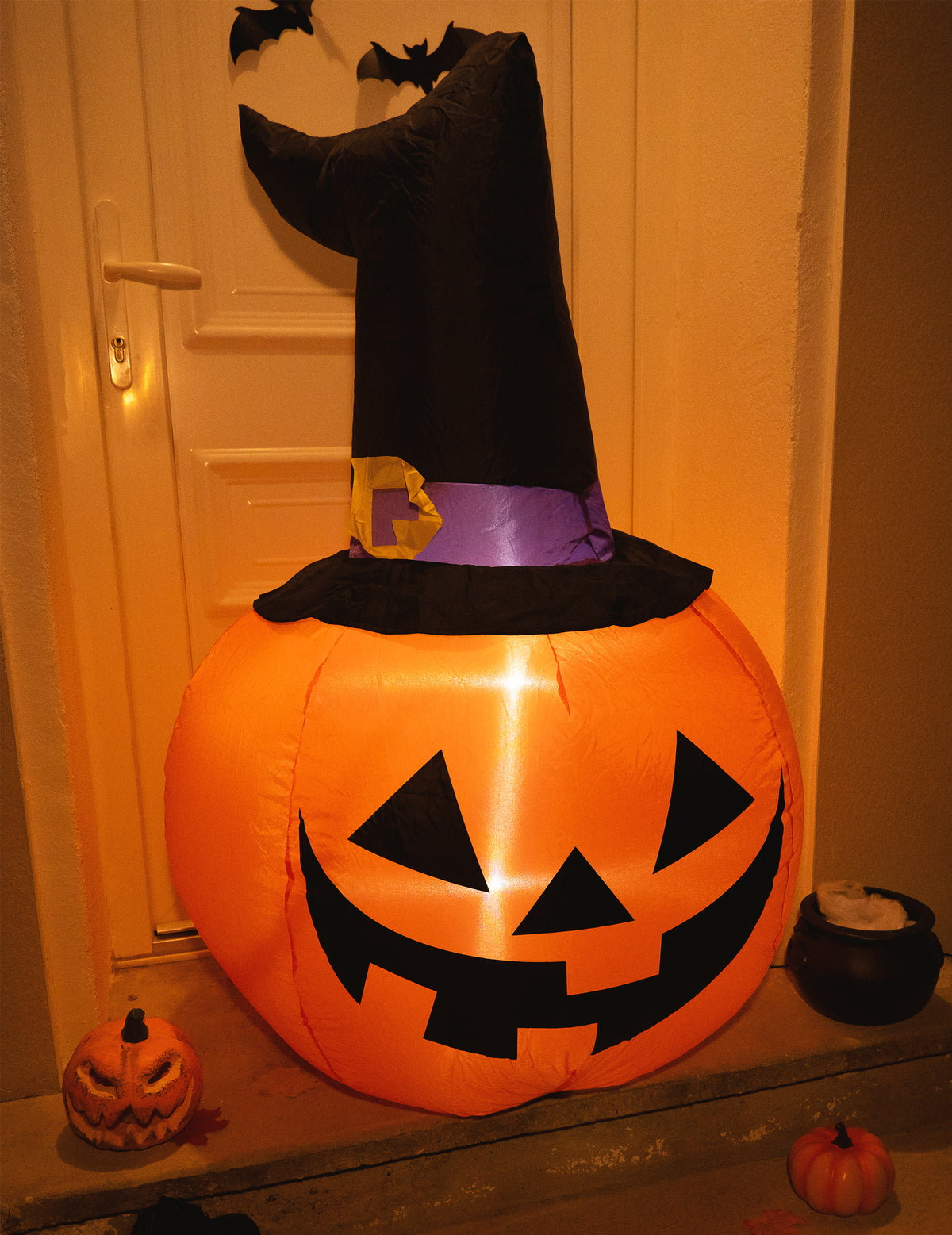 Mise en situation devant une porte de la citrouille gonflable lumineuse Halloween