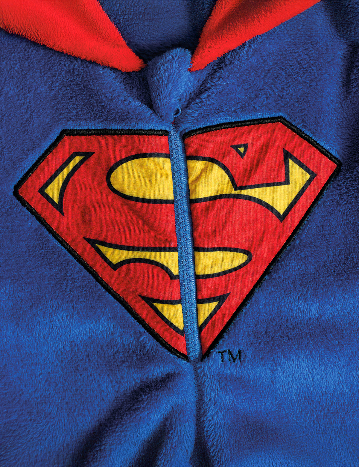 Détail du logo et de la fermeture éclair de la combinaison Superman pour enfant
