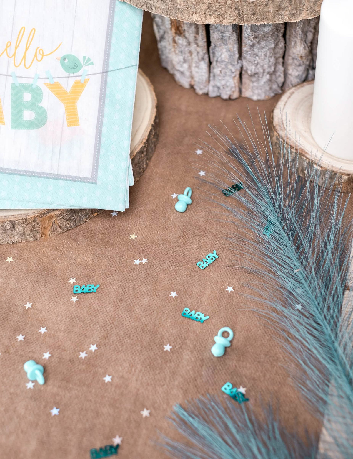 Mise en situação sobre uma mesa de confettis de chupeta baby para baby shower azul
