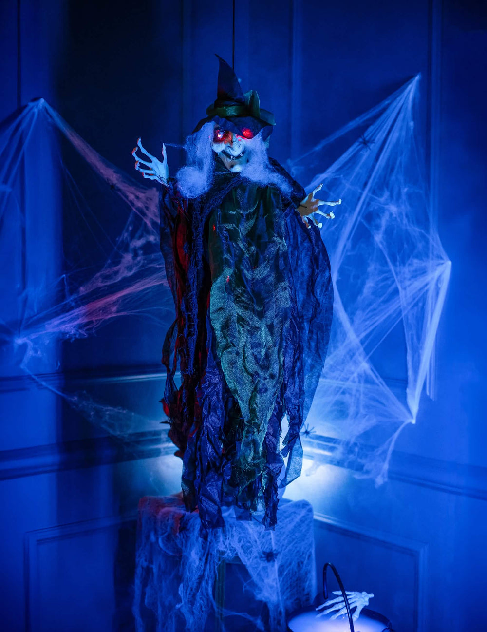 Ambientação num cenário de halloween com decoração suspensa de bruxa luminosa