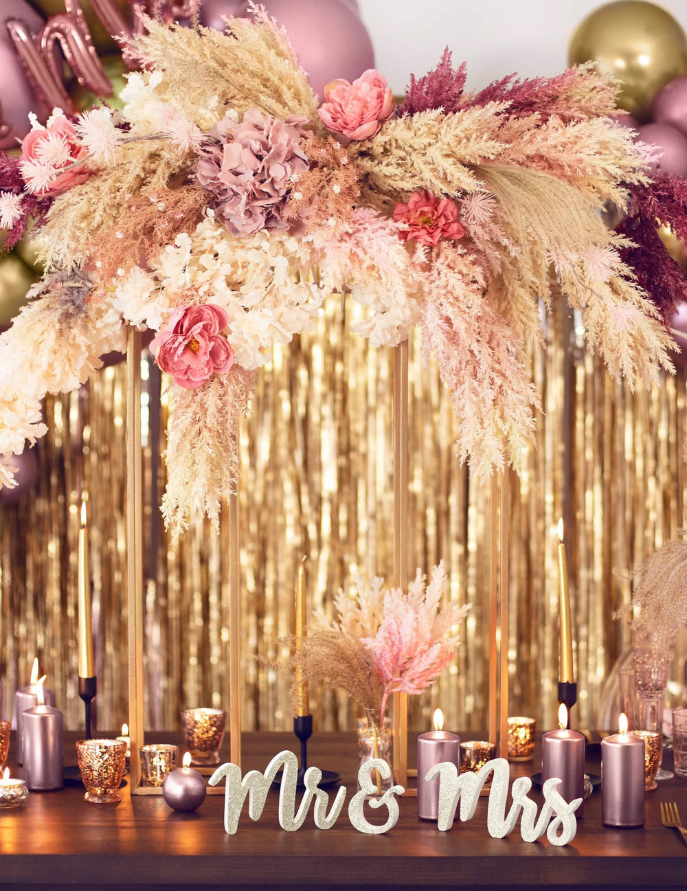 Ambiente festiva com flores e velas da decoração em madeira Mr e Mrs para casamento