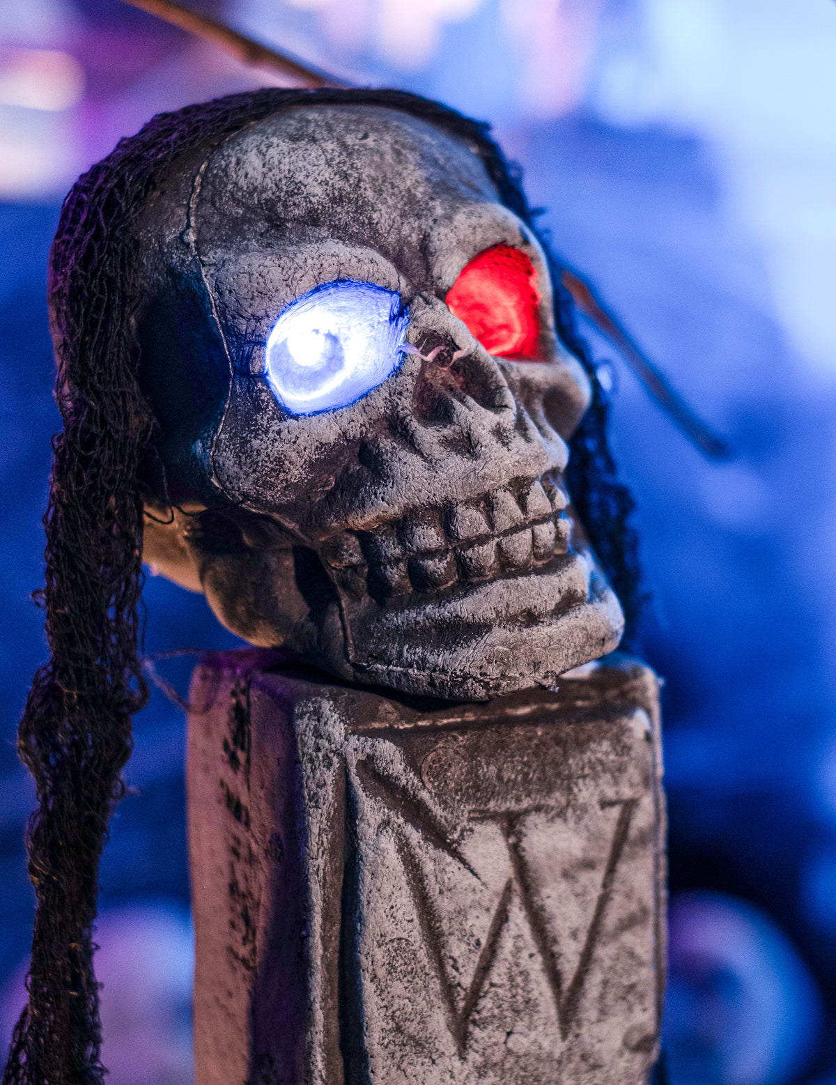Gros plan sur le crâne aux yeux LED de la décoration lumineuse devanture tombeau Halloween