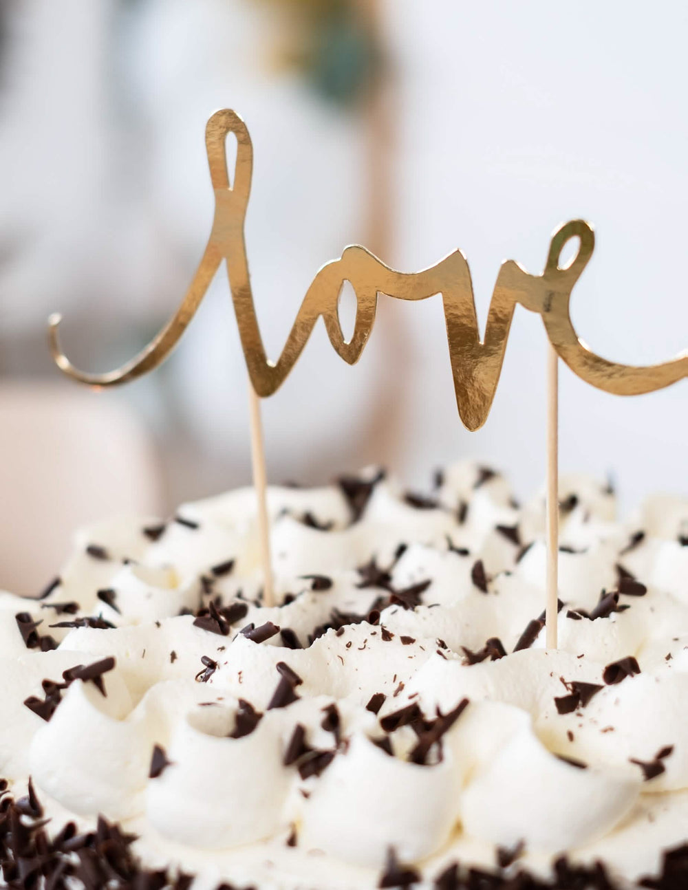 Vista aproximada de um bolo com a decoração para bolo love para casamento dourado
