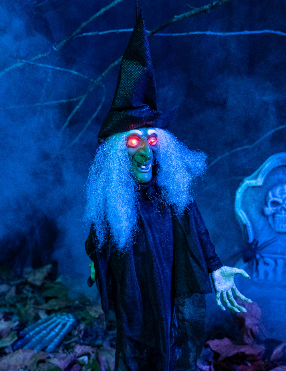 Gros plan sur les yeux rouges lumineux de la décoration sorcière animée lumineuse et parlante pour Halloween
