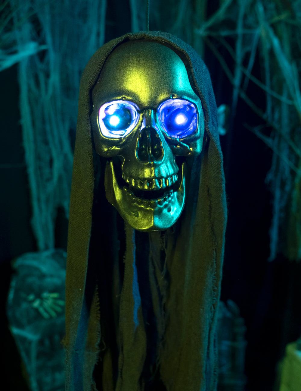 Gros plan sur les yeux bleus lumineux de la décoration tête de faucheuse à suspendre Halloween