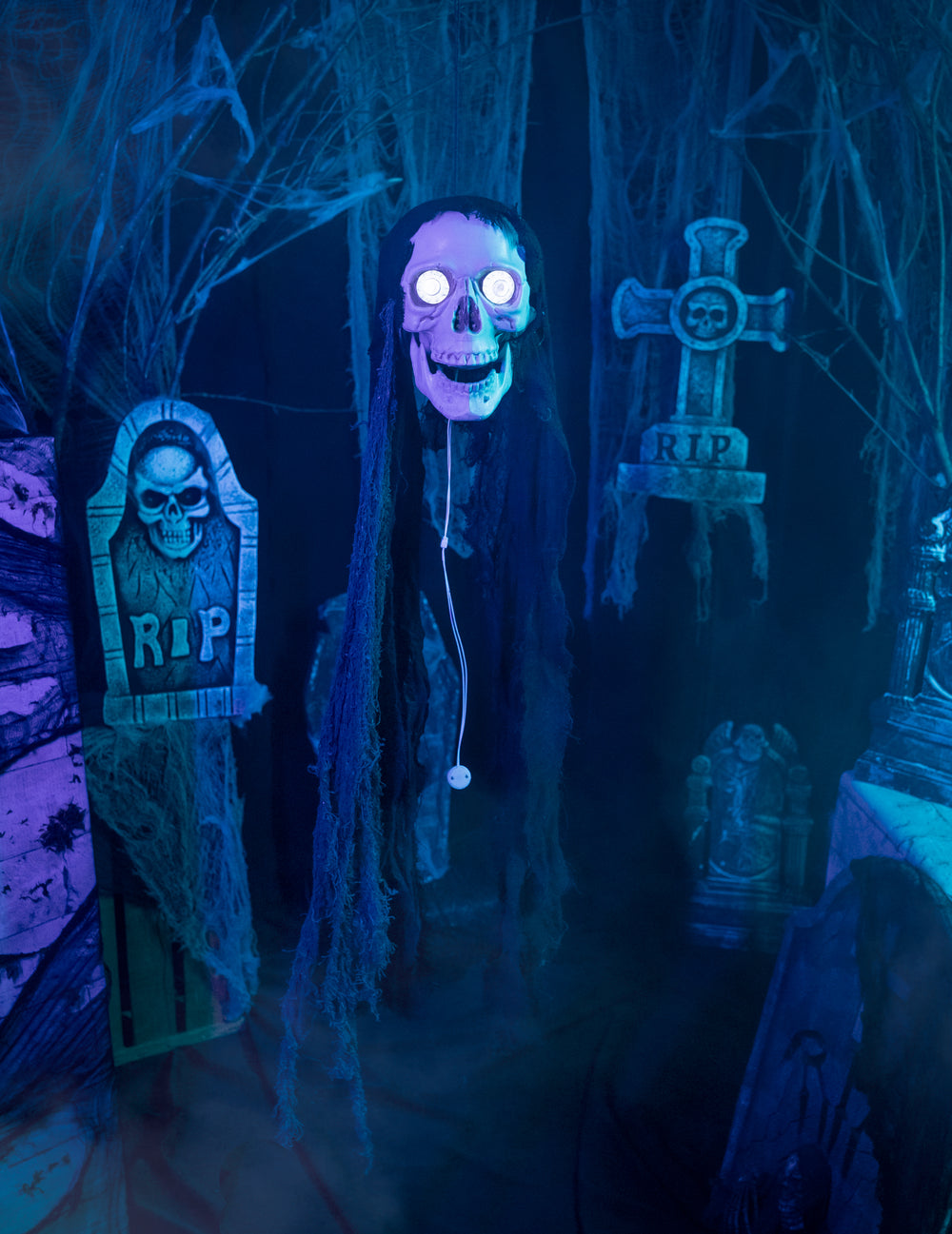 Mise en situation dans un décor de cimetière de la décoration tête de mort animée pour Halloween