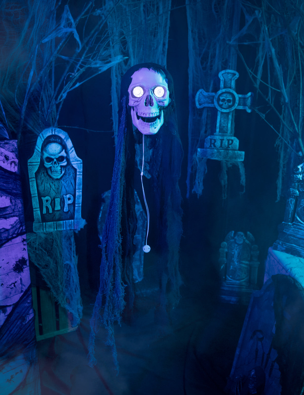 Mise en situation dans un décor de cimetière de la décoration tête de mort animée pour Halloween