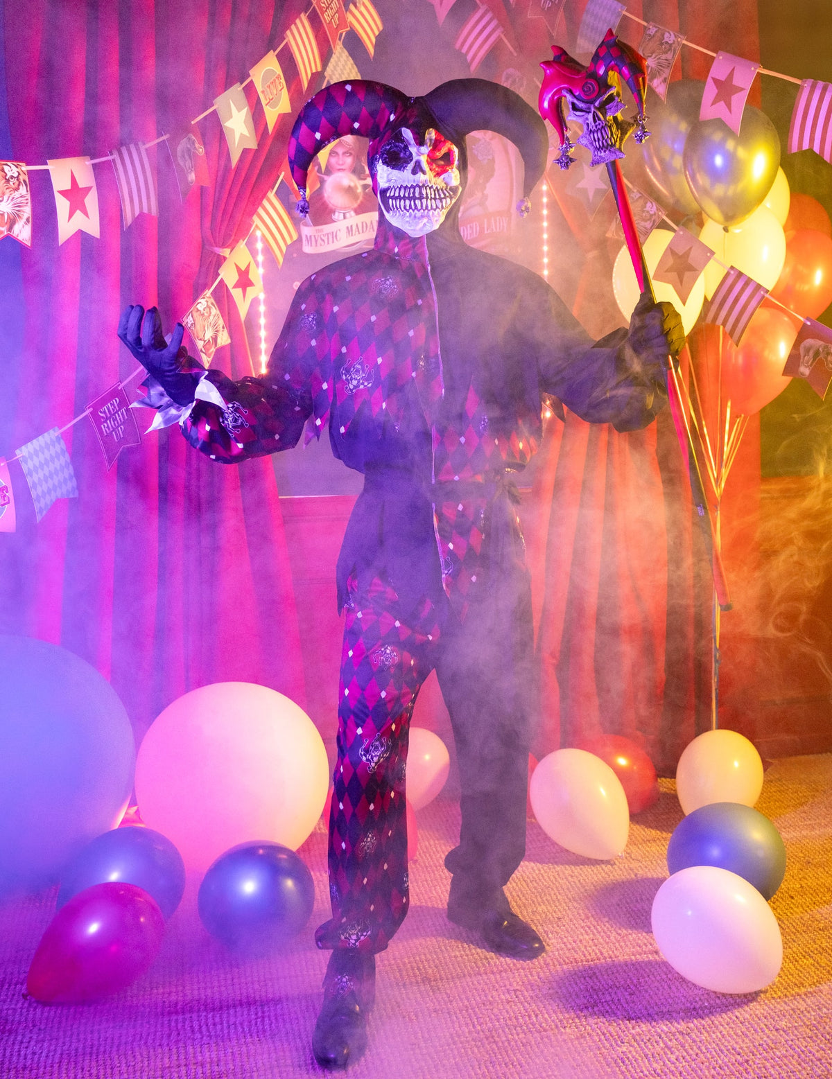 Mise en situation avec ballons et fumée du déguisement Arlequin du mal luxe pour homme