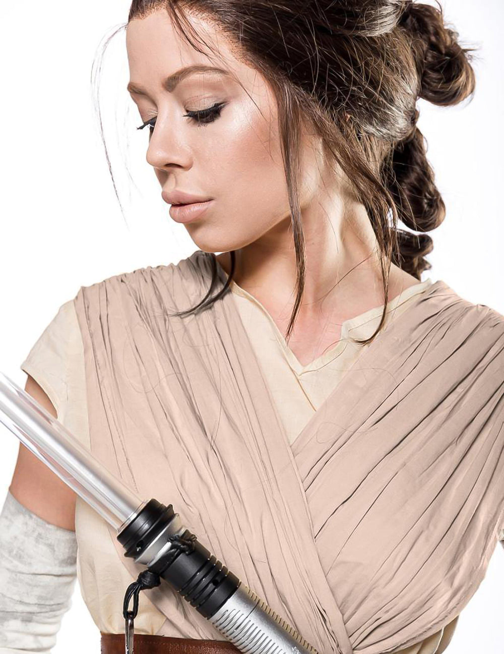Gros plan sur le buste et le sabre laser du déguisement guerrière du désert luxe pour femme