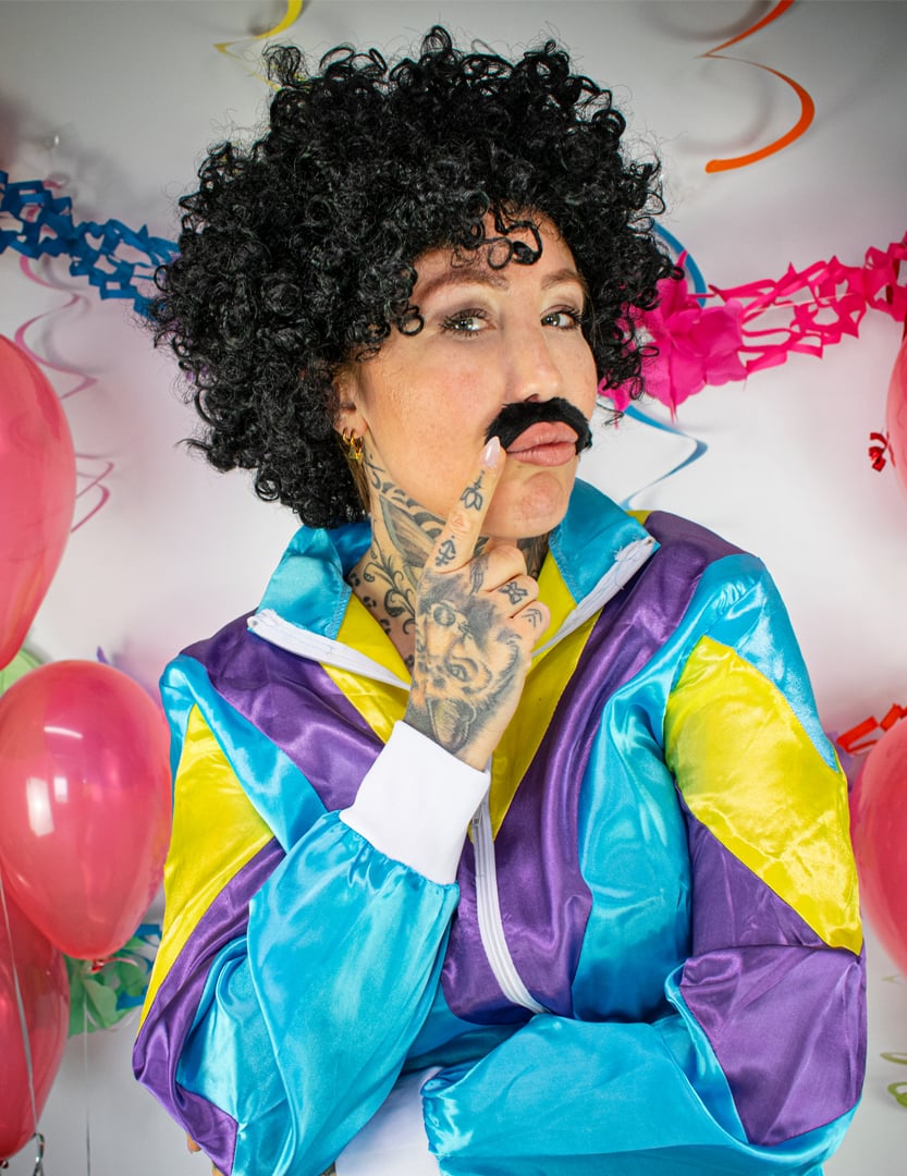 Gros plan sur la perruque et la moustache du déguisement jogging années 80 pour adulte