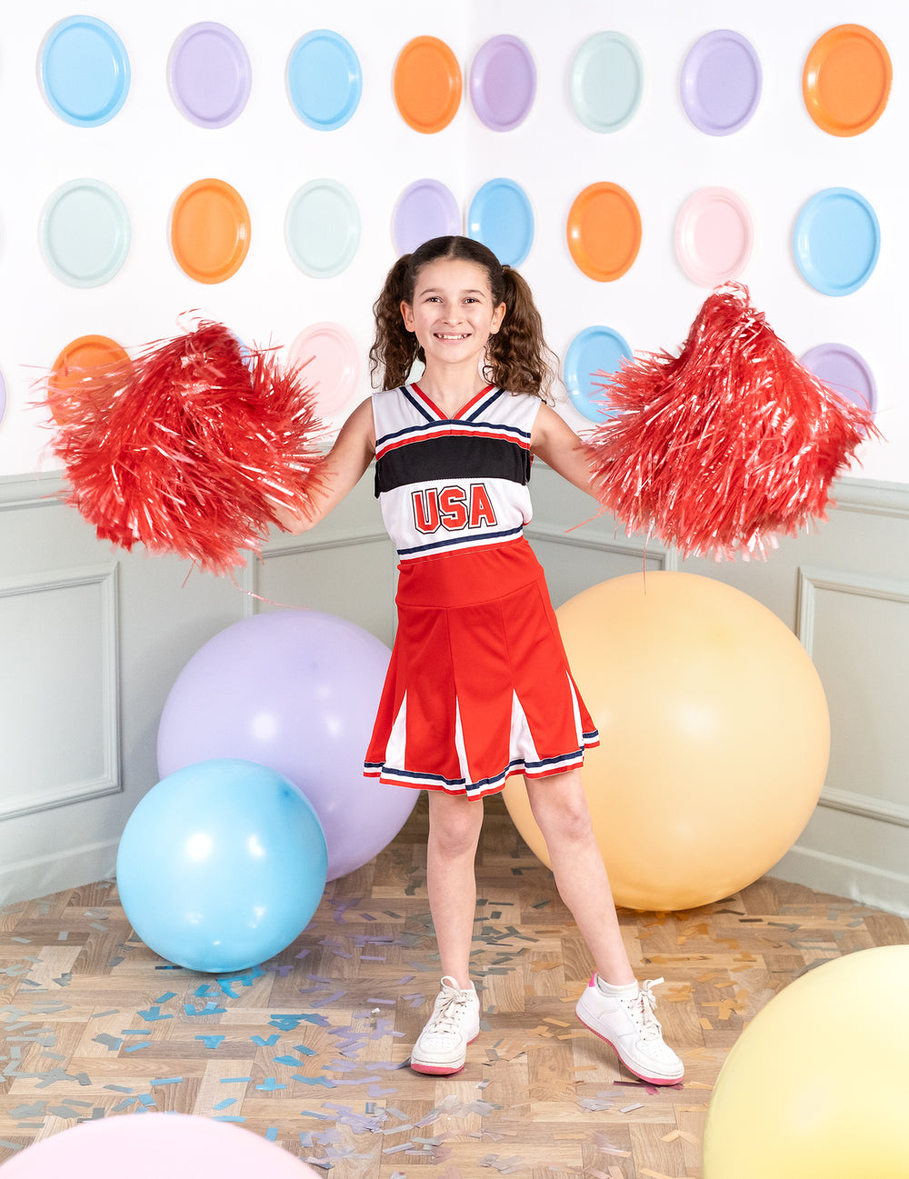 Pose de face en pied avec pompons du déguisement pompom girl USA