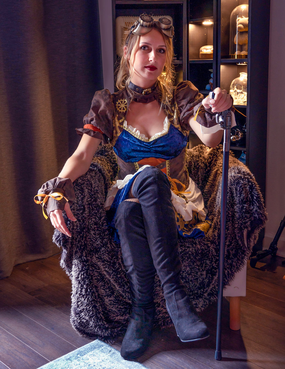 Vue de face du modèle assis avec accessoires du déguisement rétro futuriste steampunk