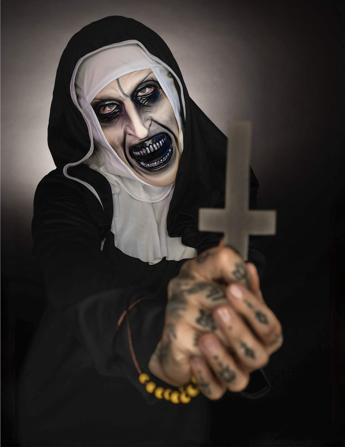 Detalhe da cruz e do rosto aterrador do disfarce The Nun™ para adulto